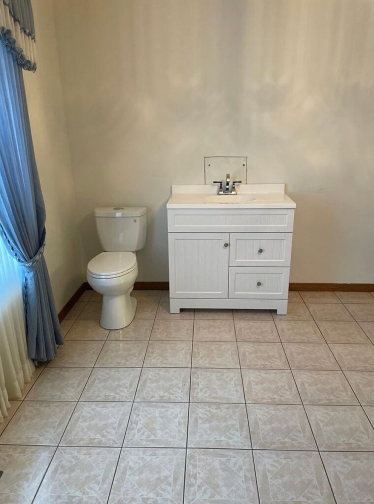 White cabinets next to toilet in powder room